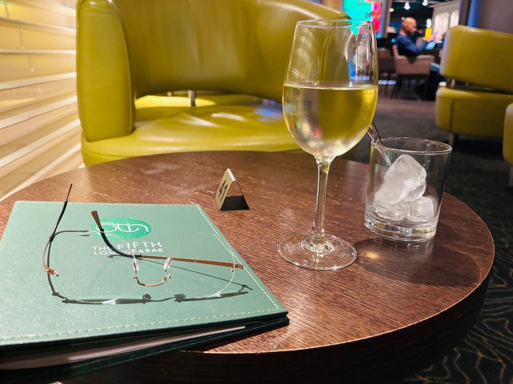 Bartisch mit Weinglas, Eiswürfelglas und Getränkekarte. 