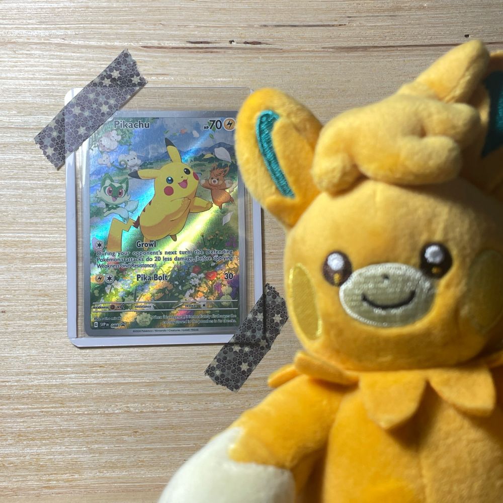 pawmot plushie in the foreground and a pokemon card taped on wood in the background