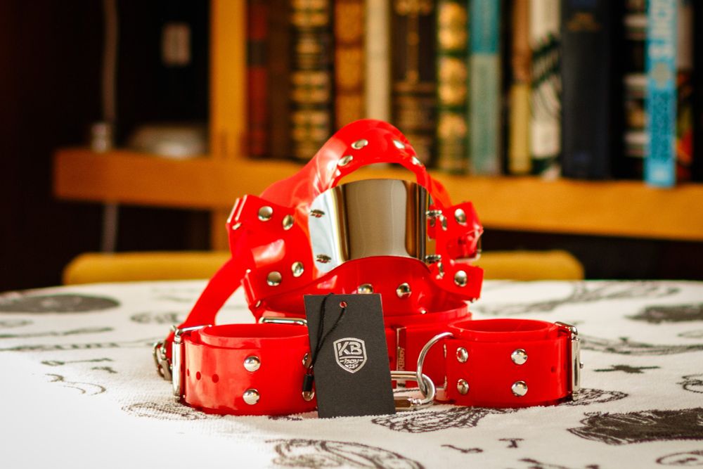 Red silicone cuffs, collar, and muzzle.