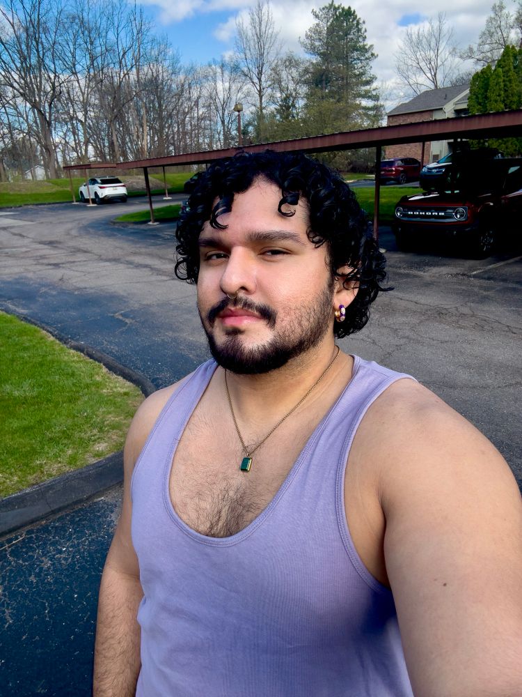 selfie of me wearing a lavender tank top and posing outside. 