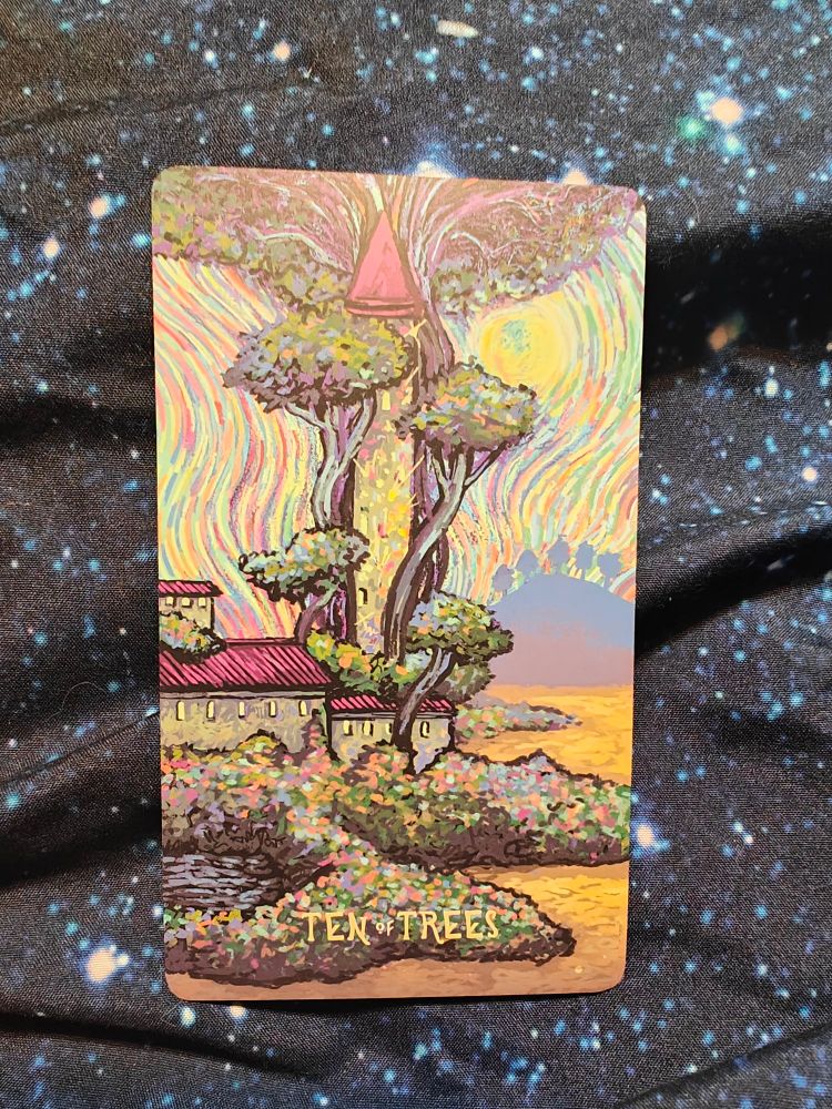 Abbey type building on the edge of a lake, a large tower grows above it, wrapped around by trees.