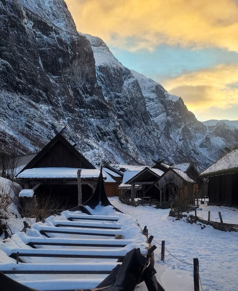 Snow covered village nestled in snow
 covered mountains. 
