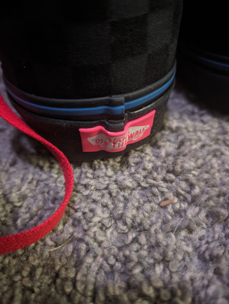 a close up of the heel of one of the shoes. the heel scab displaying the logo has been made pink, with the logo itself being white.