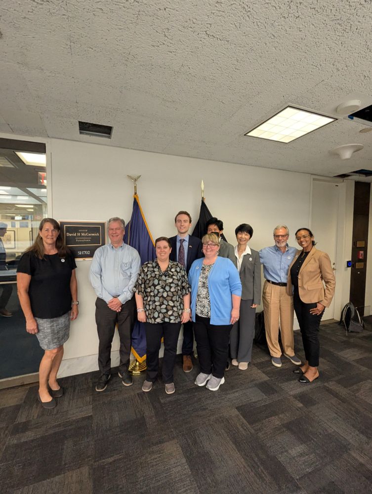 A group of physicists in the hall outside of Sen. McCormick's office with health legislation specialist Sam 