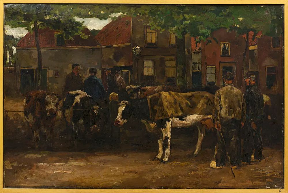Background from left to right: a row of houses with trees and a street lamp in front of them. Central in the picture: a small cattle market on a square. Several farmers standing amongst the cows. The cow nearest the front is looking to the left and has a cloth draped over its backside. 