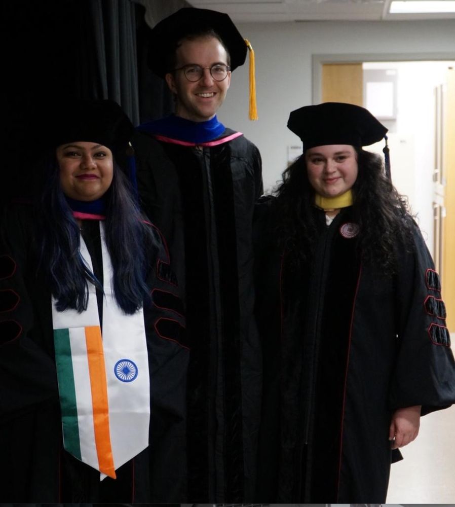 Suchi Ghosh, Ben Koch, and Allie Margets, freshly hooded, in their Ph.D. graduation robes.