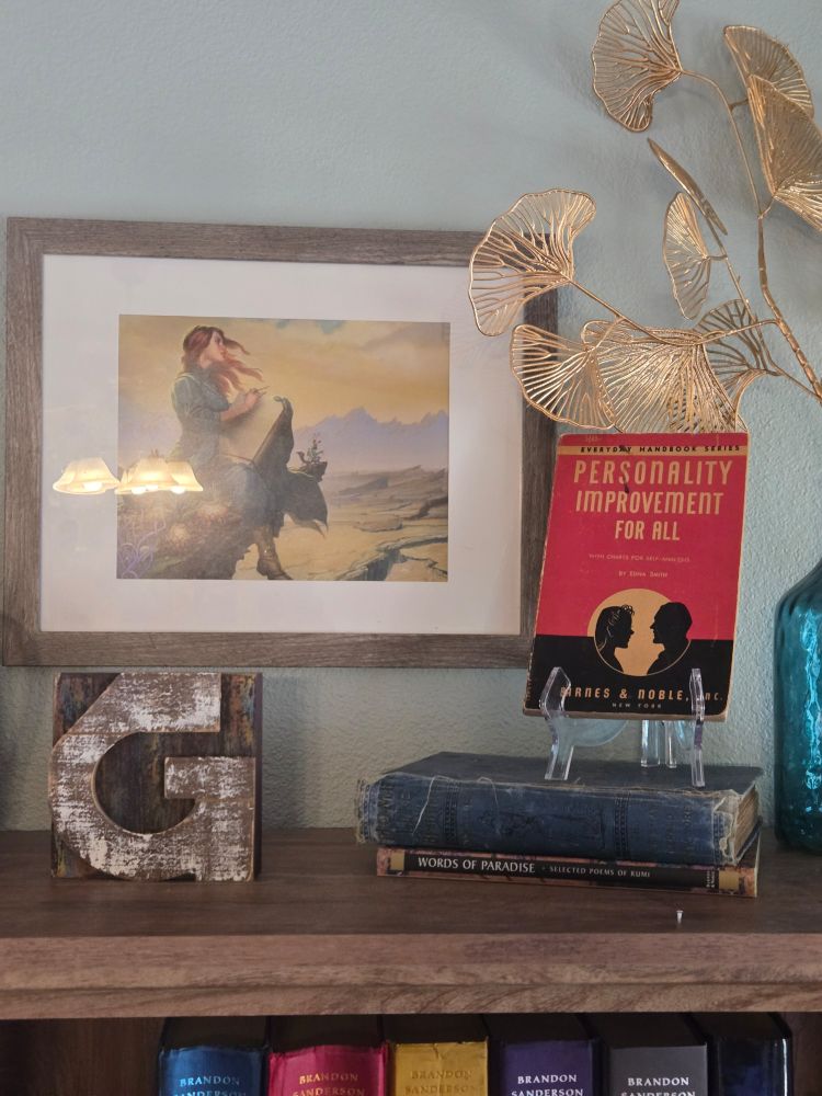 Vintage red and black book titled "Personality Improvement for All", displayed next to a painting of Shallan Davar from Brandon Sanderson's "The Stormlight Archives"