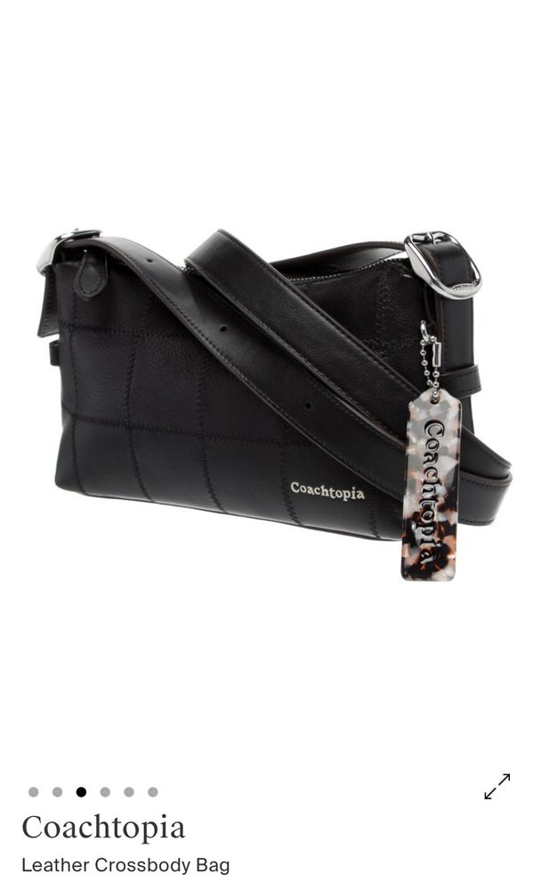 A black leather Coachtopia crossbody bag. It’s small and rectangular and features square embossed panels.
