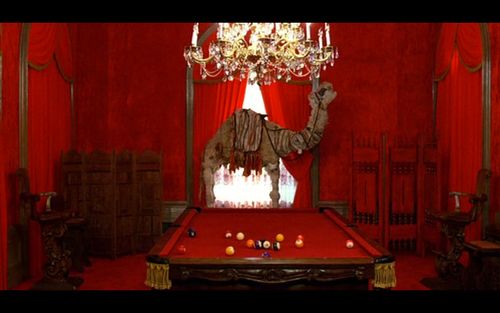 An all-red billiard room with a giant stuffed camel 