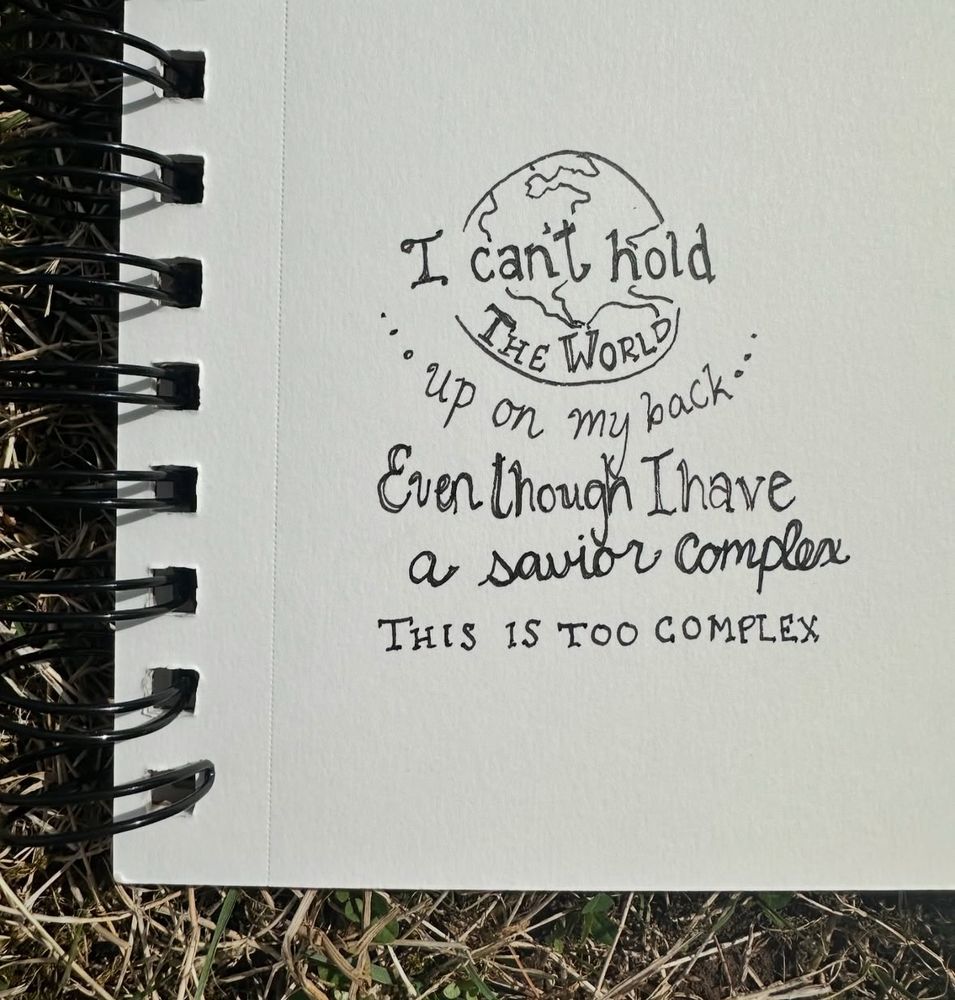 Hand drawn doodle of a globe on a notebook page with the lyrics of a song written overtop 