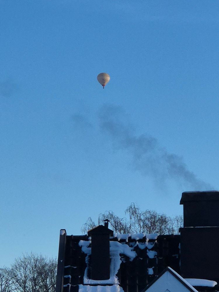 A random hot air balloon flying over the neighbourhood in the middle of winter