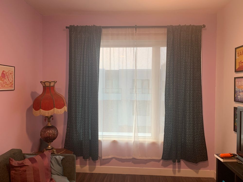 my living room window with new gauzy white curtains drawn over it and green damask on either side 