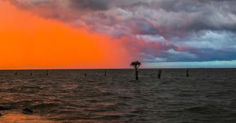 A sunset with storm clouds over the water