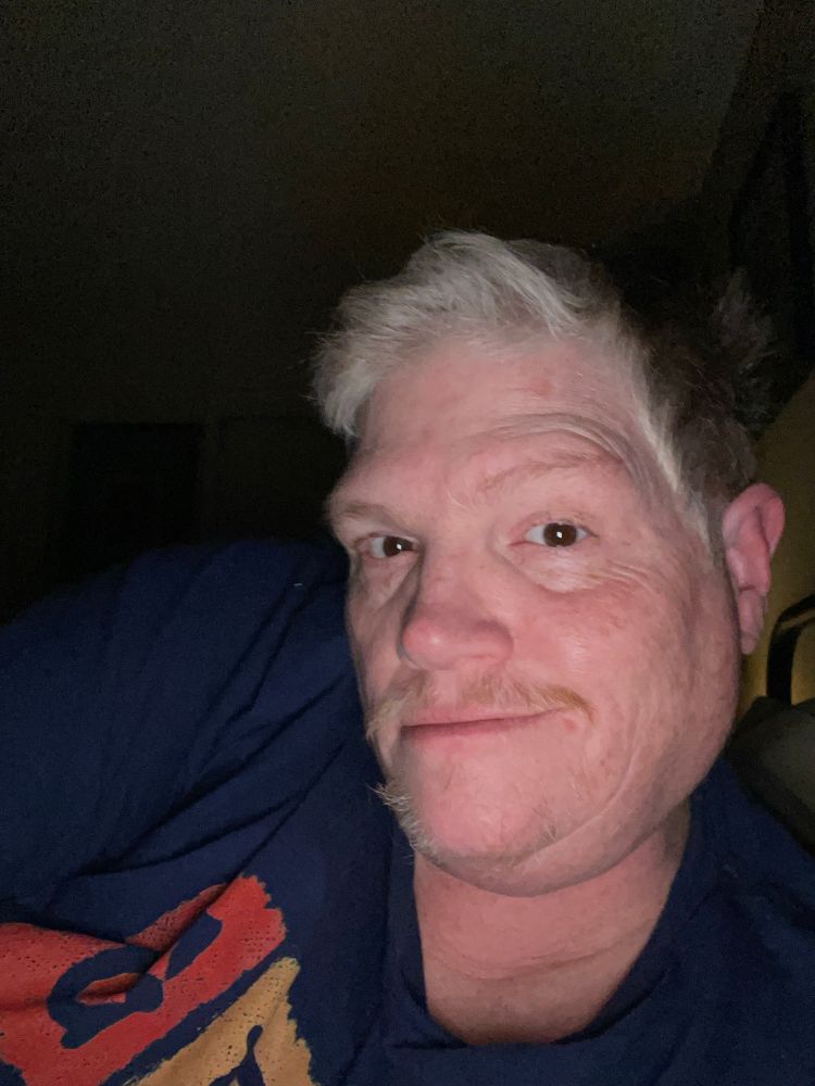 Man with short hair and a black shirt.