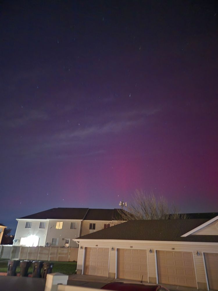 Faint pink shimmer over the houses