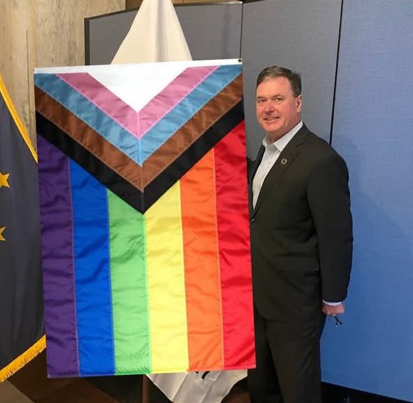 Indiana's Attorney General Todd Rokita standing beside an LGBTQIA+ flag.

If you are reading the alt text I'll give you the bonus content: this was part of an "April Fools" Facebook post he made today where he said "The Left wins... They have finally brainwashed me. I am taking down our 'Come And Take It' flag and replacing it with this one. April Fools!"

Evidently he didn't realize that we can just TAKE THIS PHOTO HE POSED FOR and share that without the benefit of the other post. HOWEVER -

The other flag Todd is referring to is one with a giant cannon shaft on it that says "COME AND TAKE IT." So that is also going on.