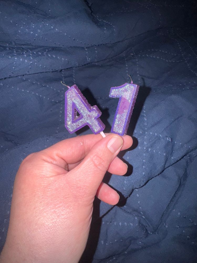 A Purple and green 4, and 1 birthday candles. 