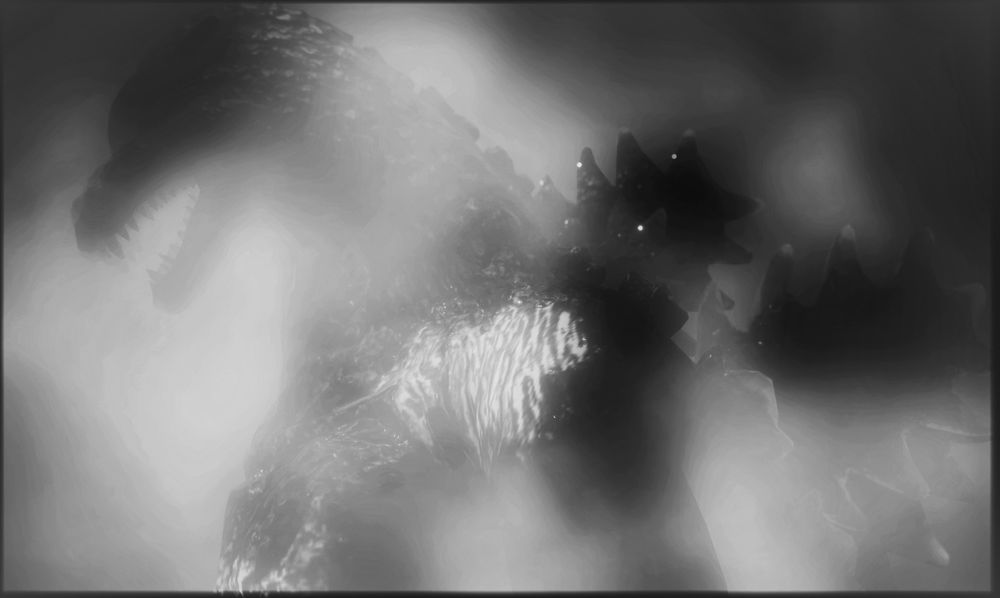 Black and white shot of Godzilla covered by smoke.