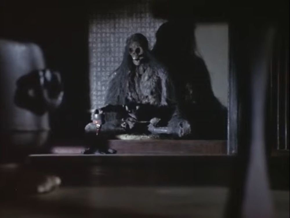 A frame from the show Horror Theater Unbalance (恐怖劇場アンバランス) produced by Tsubaraya Productions in 1973.

It comes from the first episode, Love Affair With a Mummy, directed by Seijun Suzuki with cinematography by Yoshihiro Mori.

The skeleton of a monk sits alone in the darkness of an old home. It rings a cup-like gong, despite seemingly being dead.