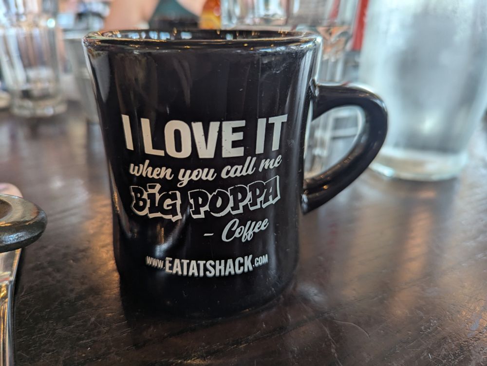 A mug that says "I love it when you call be big poppa -coffee" from shack