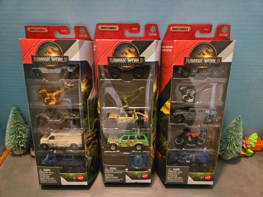 MBX Jurassic World 5 Pack 1.
1. Jurassic World Jeep Wrangler.
2. Orange Atrociraptor.
3. Jurassic World InGen Vehicle.
4. Beige Ford Panel Van.
5. Jurassic World Offroad Rescue.
MBX Jurassic World 5 Pack 2.
1. Jurassic World Capture Action Truck. 
2. Green Dilophosaurus.
3. Jurassic World 2019 Jeep Gladiator. 
4. Jurassic Park 1993 Ford Explorer.
5. Jurassic World Gyrosphere.
MBX Jurassic World 5 Pack 3.  
1. Jurassic World 1997 Mercedes-Benz ML 320.
2. Blue the Velociraptor.
3. InGen Humvee.
4. Red Speed Striker Motorbike.
5. Jurassic World Armor Action Truck.