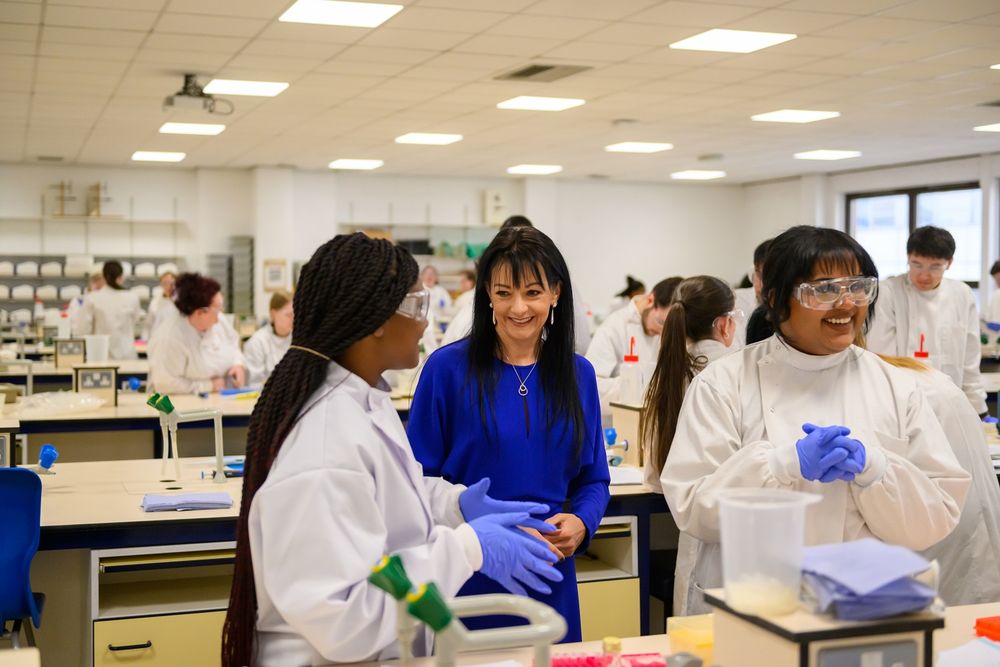 Professor Catherine Ross talking to GCU students in a laboratory during the visit.