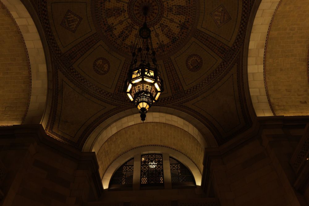Brick ceiling with arches and a big chandelier.