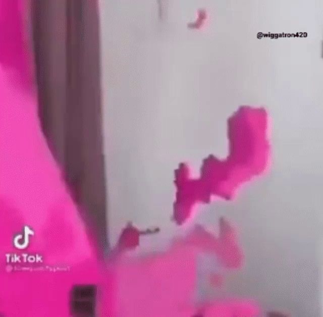 a person is standing in a room with pink smoke coming out of the ceiling .