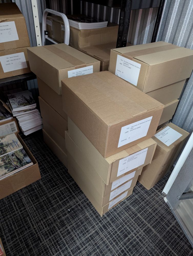 Piles of boxes and books in a storage unit.