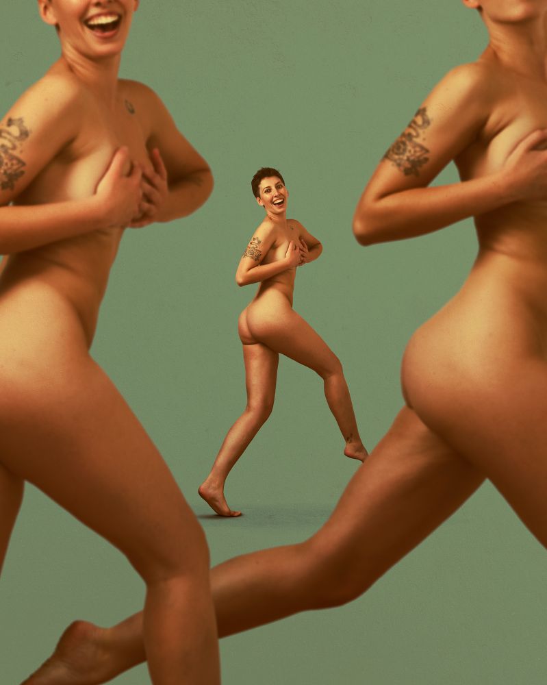 A beautiful woman jumping in the nude. There are two more versions of her jumping in the foreground. They are slightly blurred 