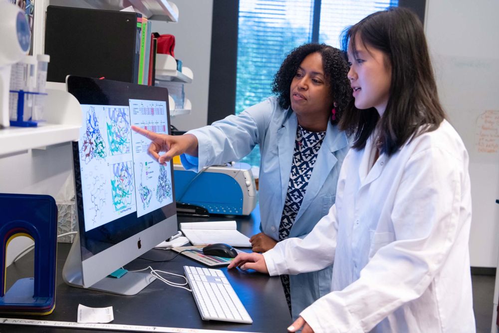 Two scientists looking at a computer screen 