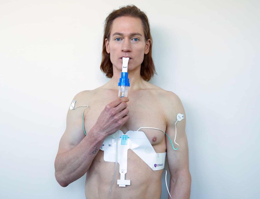 Tech CEO Bryan Johnson posing with some odd medical-ish equipment strapped to his chest. 