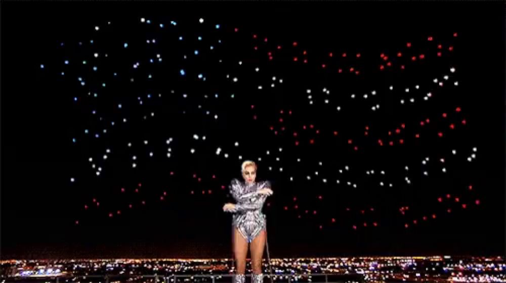 a woman is dancing in front of a fireworks display in the night sky .