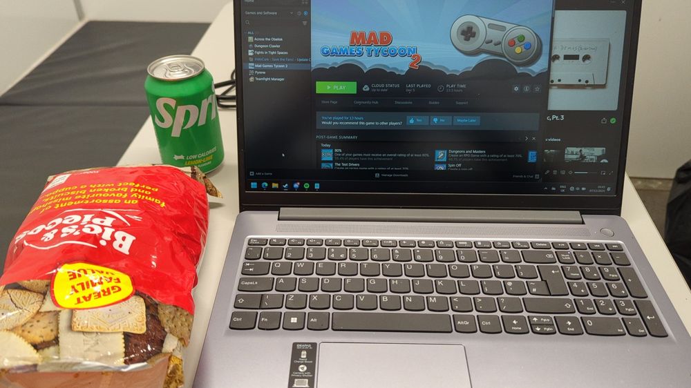 Image of a laptop, a drink and some biscuits