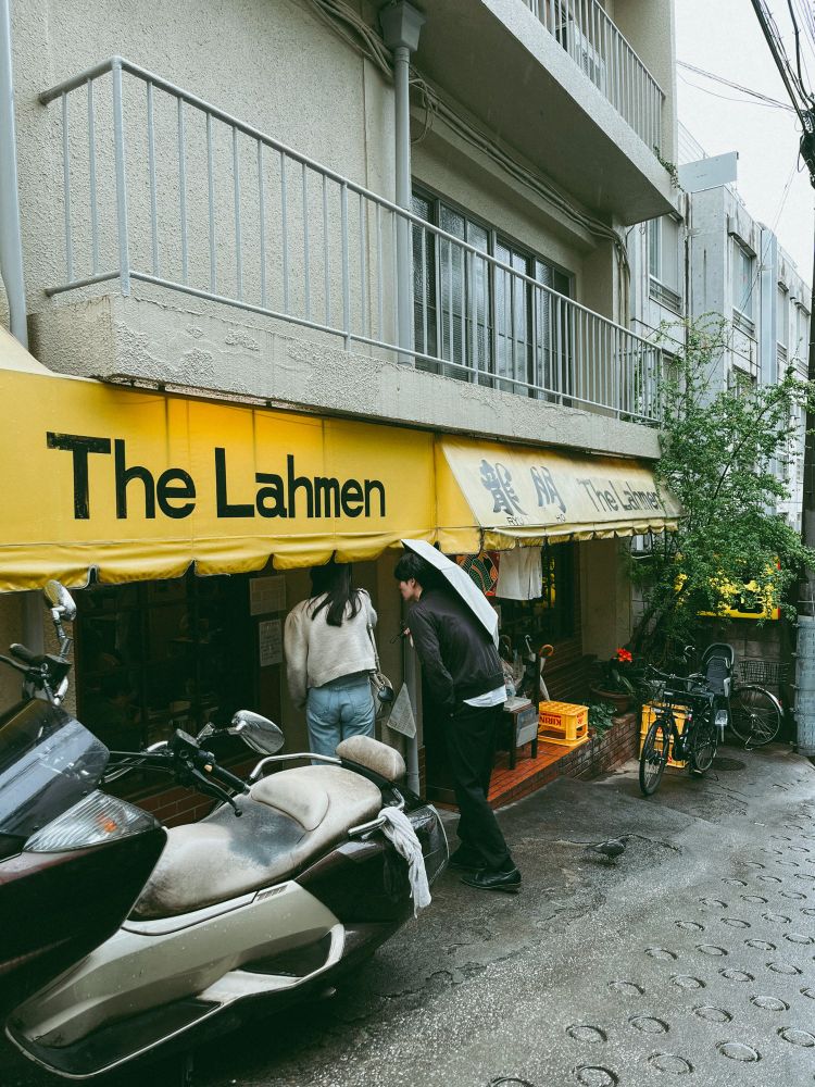 龍朋の外観
黄色い看板
女の人と男の人が店内を覗き込んでいる

雨が降っているので、男の人は傘をさしている