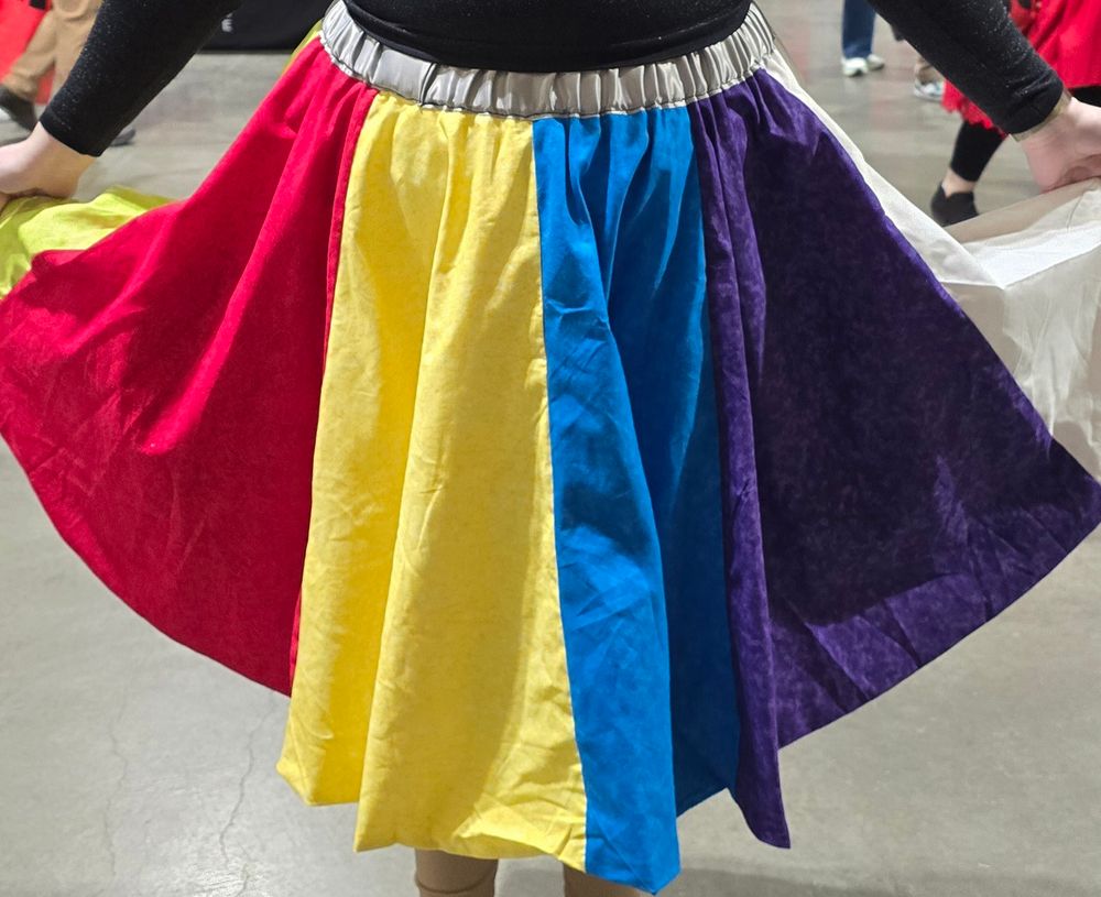 A woman displaying a multicolored skirt.
