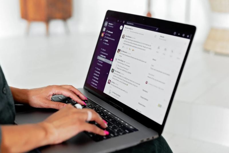 hands typing on laptop with chat app on the screen. Image by Mikhail Nilov via Pexels