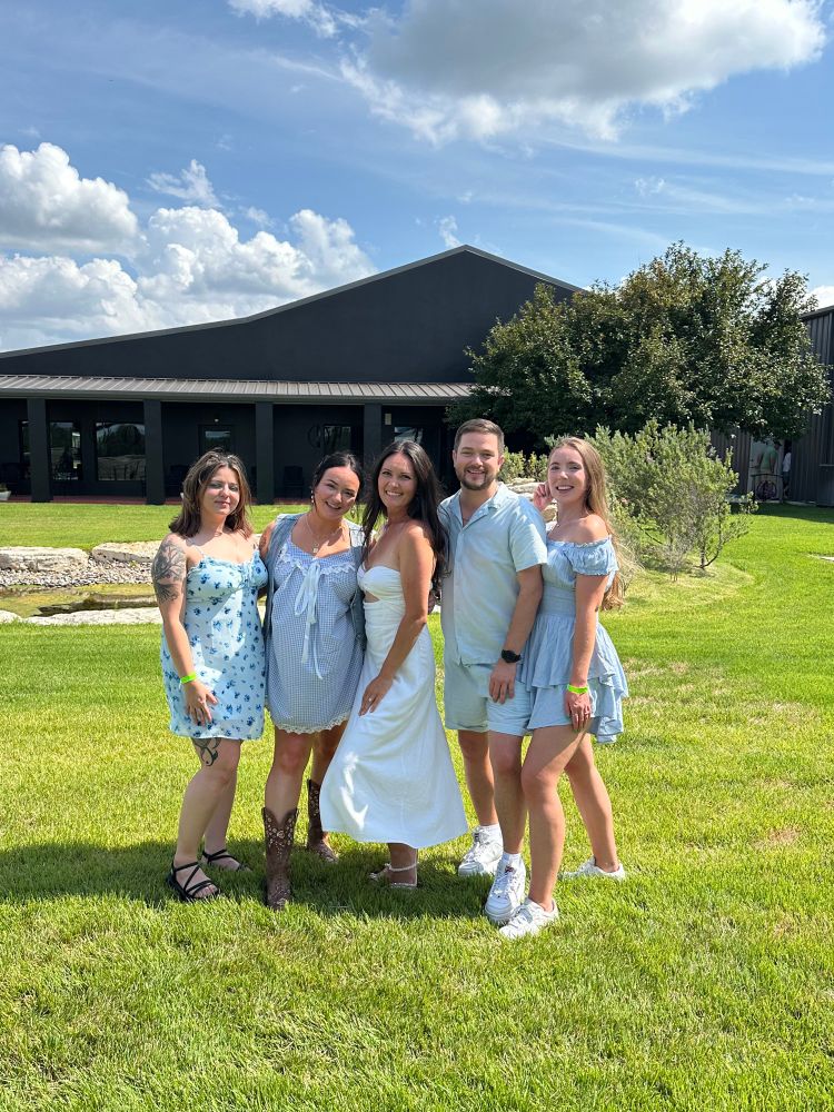 Same set up as the last photo but it is not an action shot. The bride to be in white is flamed by two friends on her left and two friends on her, right. Everyone is smiling really nicely and looks really good. 