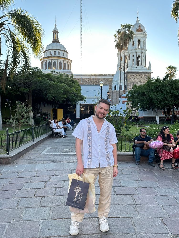 I’m standing in Guadalajara Mexico with some shopping bags and a beautiful town Square