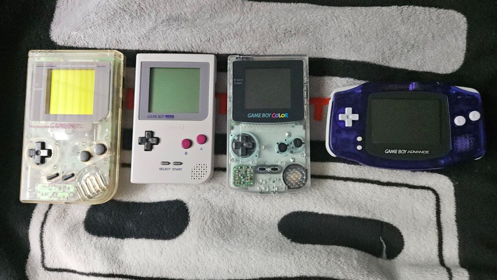 My Game Boy system collection.

The models are:
Play it Loud Clear Game Boy, Gray Game Boy Pocket, Neotone Ice Game Boy Color, and Midnight Blue Game Boy Advance.

The Midnight Blue Game Boy Advance is a Japanese Toys R Us exclusive! I'm pretty sure these are all Japanese except for the Play it Loud Game Boy.