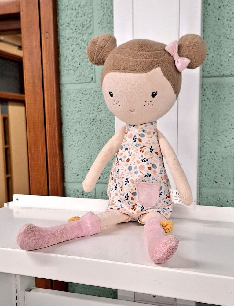 A doll wearing a dress and pink boots with buns in her hair