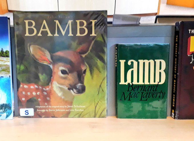Two books on a shelf. One is the book of Bambi and the other is Lamb by Bernard MacLaverty, so it reads Bambi Lamb.
