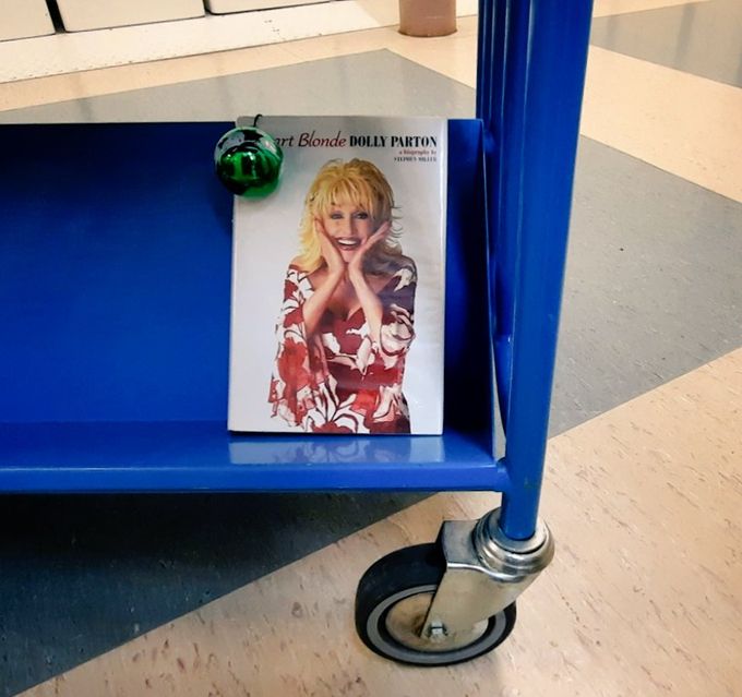 The book Smart Blonde by Dolly Parton on a blue library trolley