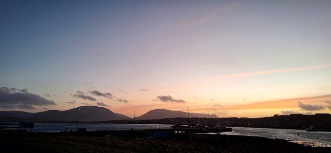 The island of Hoy photographed from Stromness. The sun is setting but the sky is still light.