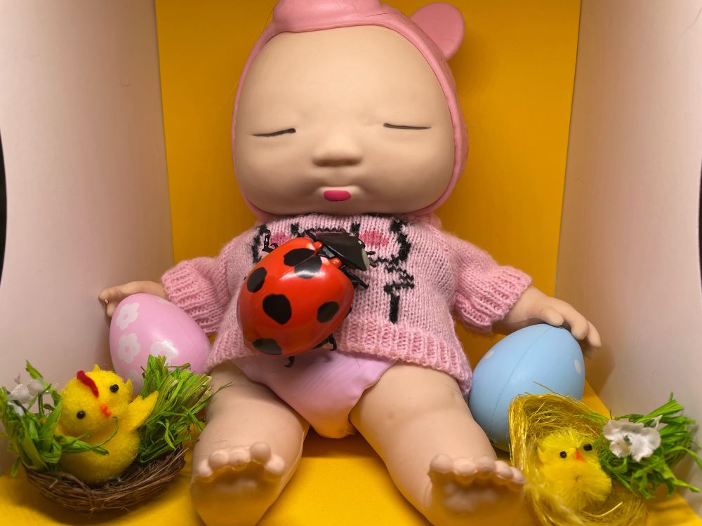 両手にひよことイースターエッグのアグリーベイビーとテントウムシ