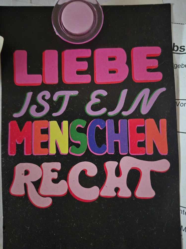 Postkarte an Pinnwand: Liebe ist ein Menschenrecht
