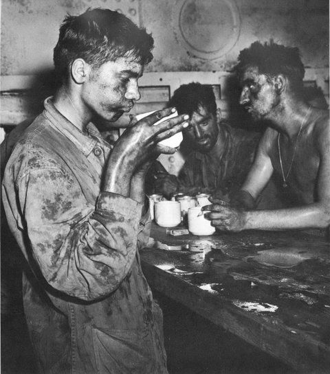Battle-weary Marines of the 22nd Regiment drinking coffee after heavy fighting on Einwetok Atoll in the Pacific Theater in February 1944. Credit National Archives and Records Administration. 