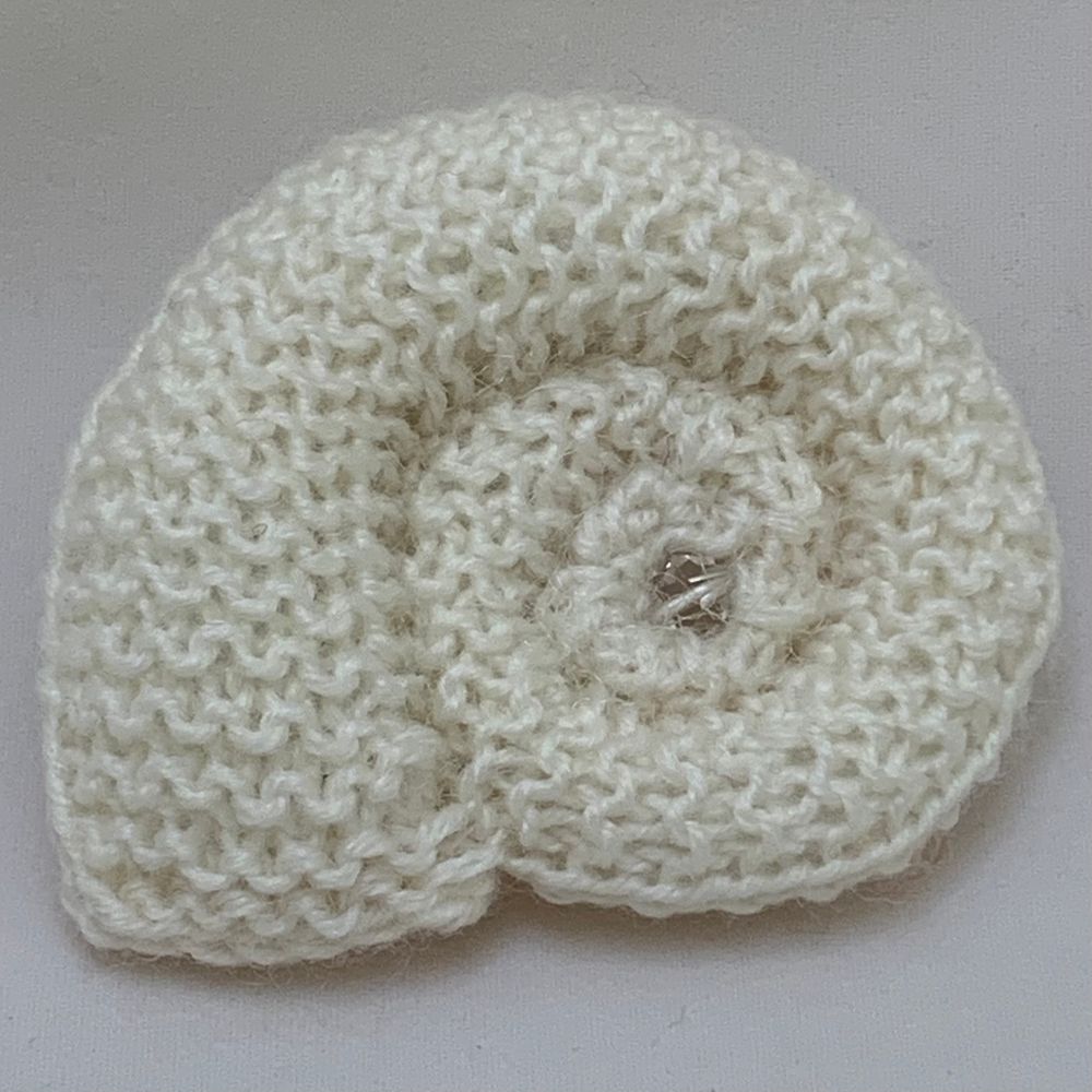 Close-up of a knitted spiral in natural merino wool 