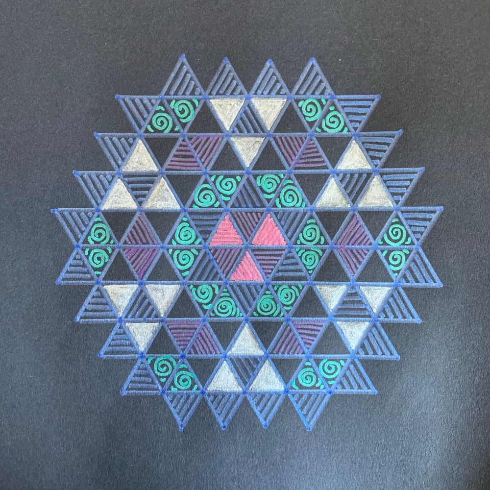 Hexagonal geometric art in zentangle style drawn with blue, silver, pink, and green metallic pen on black paper 
