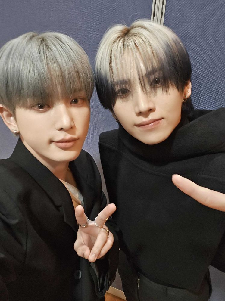 Harua and Yuma dressed all in black taking a selfie.